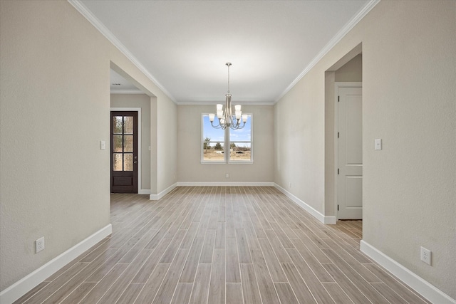 spare room featuring crown molding, a chandelier, and light wood-type flooring