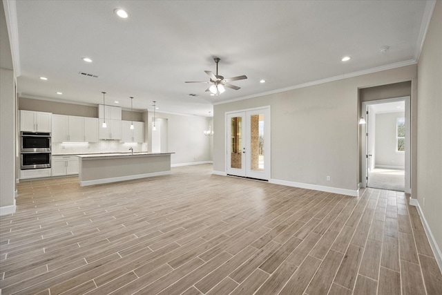 unfurnished living room featuring ceiling fan, light hardwood / wood-style floors, crown molding, and french doors