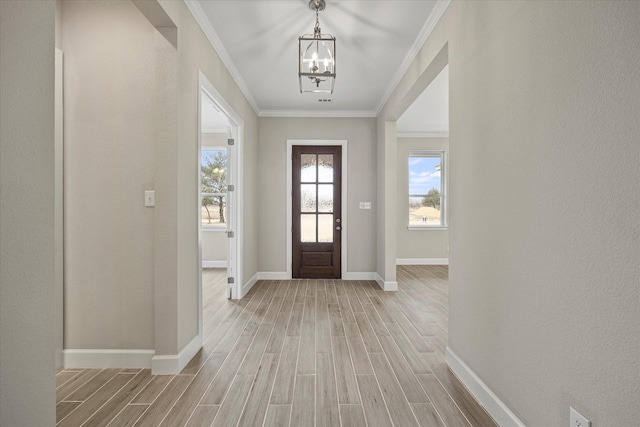 entrance foyer with light wood-type flooring, an inviting chandelier, and crown molding