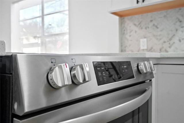 room details featuring white cabinetry and stove