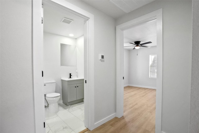 bathroom with toilet, hardwood / wood-style flooring, ceiling fan, and vanity