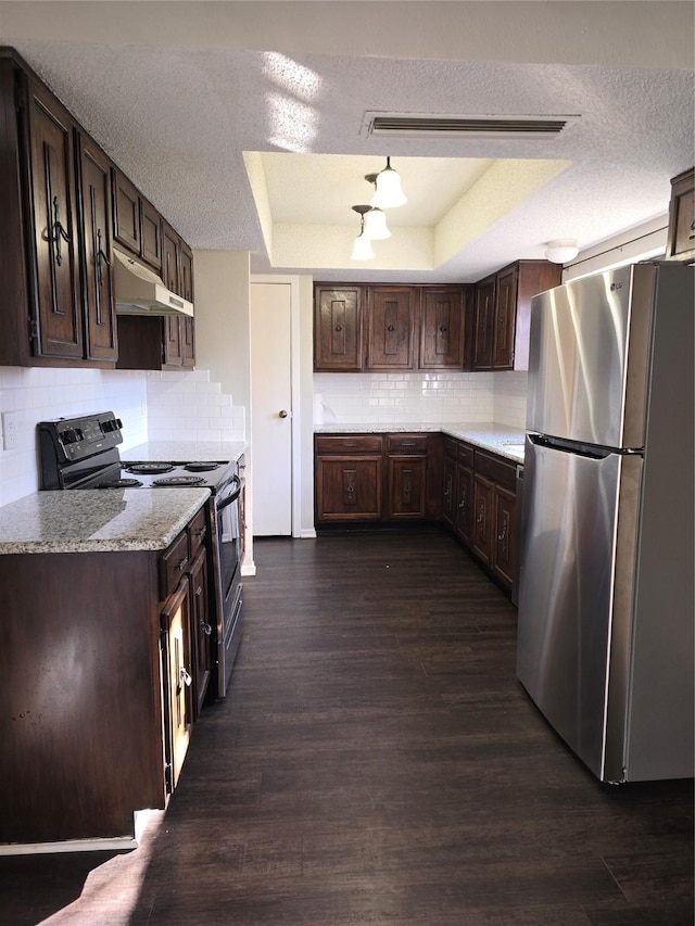 kitchen featuring light stone counters, a tray ceiling, stainless steel refrigerator, black electric range, and dark brown cabinetry