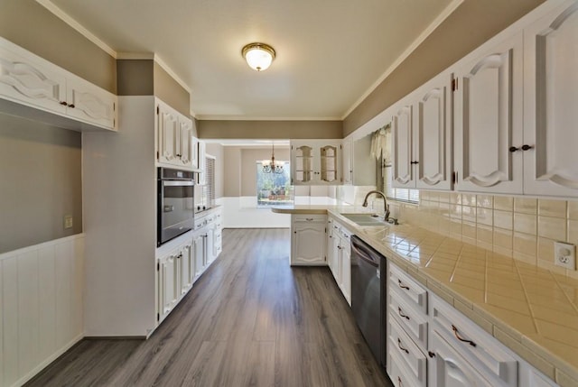 kitchen featuring white cabinetry, tile counters, sink, decorative light fixtures, and appliances with stainless steel finishes