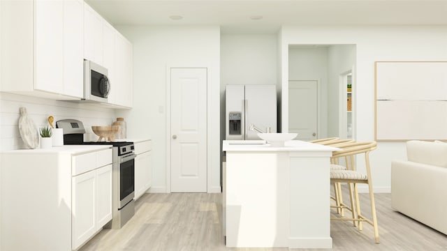 kitchen with stainless steel range, light hardwood / wood-style flooring, white cabinets, white fridge with ice dispenser, and a breakfast bar area