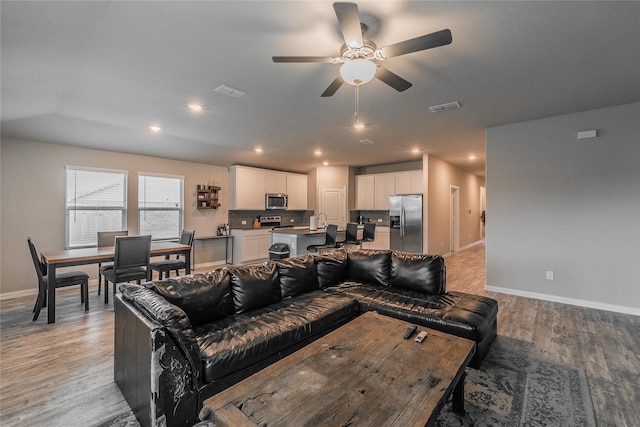 living room with ceiling fan and light hardwood / wood-style floors