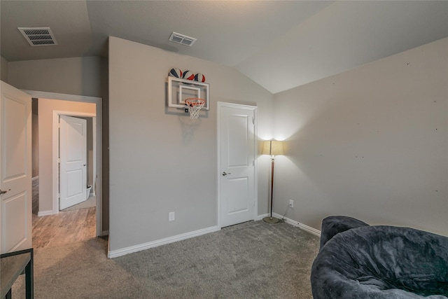 sitting room with carpet floors and vaulted ceiling