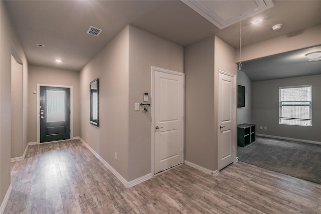 foyer with wood-type flooring and ornamental molding