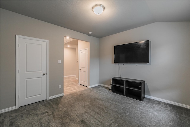 unfurnished living room featuring carpet flooring and vaulted ceiling