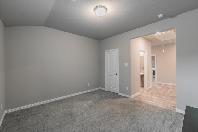 spare room with carpet floors and vaulted ceiling