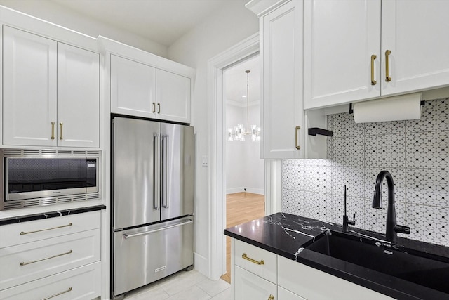 kitchen featuring sink, stainless steel appliances, white cabinetry, and tasteful backsplash