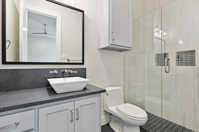 bathroom with ceiling fan, tasteful backsplash, toilet, walk in shower, and vanity