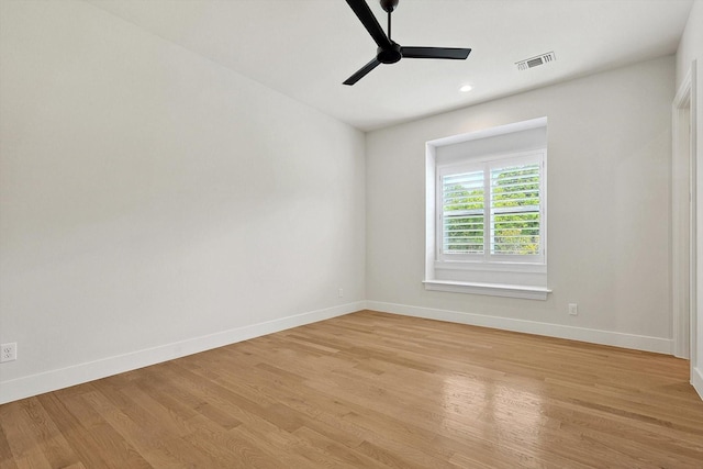 empty room with ceiling fan and light hardwood / wood-style flooring