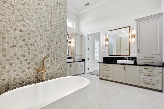 bathroom with a high ceiling, ornamental molding, a tub to relax in, and vanity