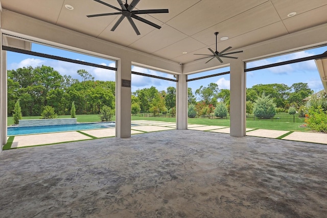 unfurnished sunroom with ceiling fan