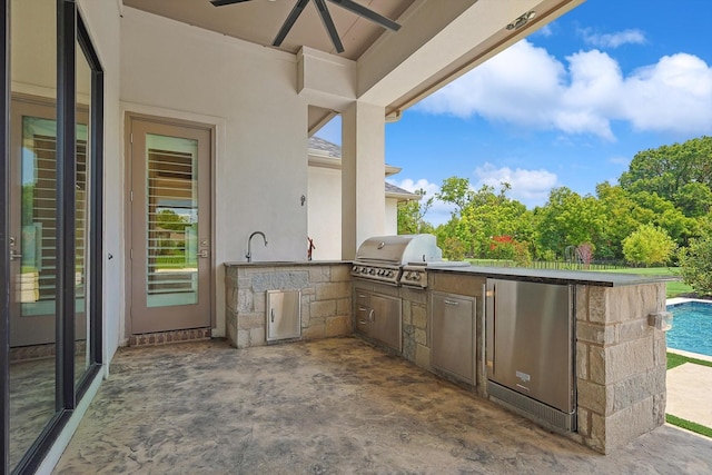 view of patio / terrace with ceiling fan, a grill, sink, and exterior kitchen