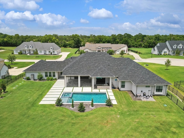 back of house featuring a lawn, a fenced in pool, and a patio