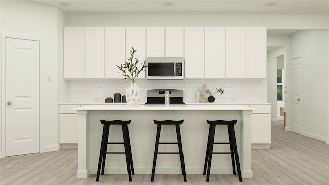 kitchen with white cabinets and a kitchen island with sink