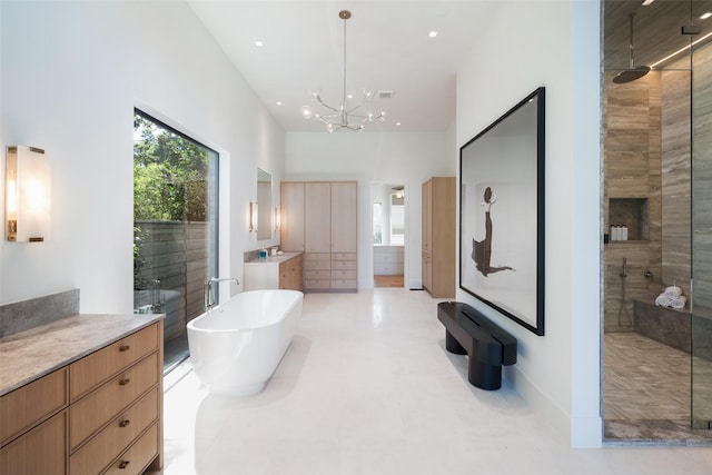 bathroom with plus walk in shower, tile patterned floors, vanity, and an inviting chandelier