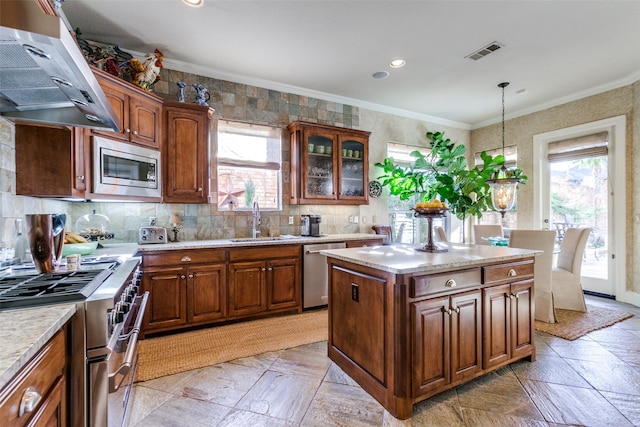 kitchen with stainless steel appliances, a center island, ornamental molding, sink, and extractor fan