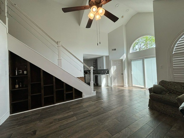 living room featuring ceiling fan, hardwood / wood-style floors, and high vaulted ceiling