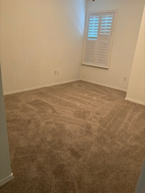 spare room with dark carpet