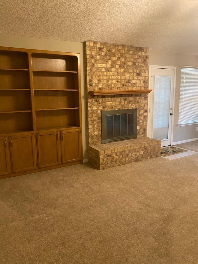 unfurnished living room featuring carpet flooring, a textured ceiling, and a fireplace