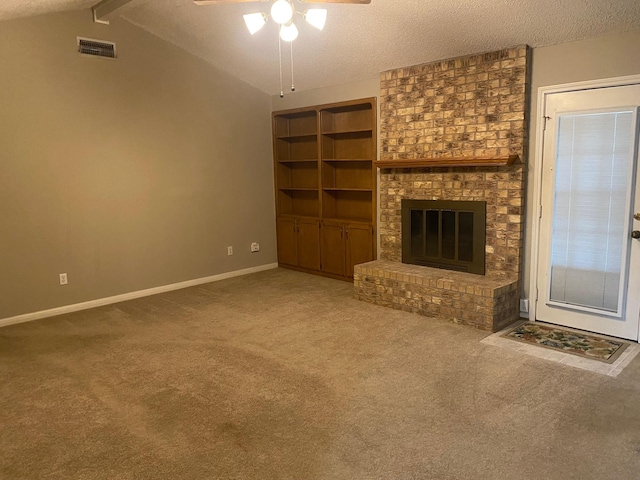 unfurnished living room with carpet flooring, ceiling fan, lofted ceiling with beams, a textured ceiling, and a fireplace