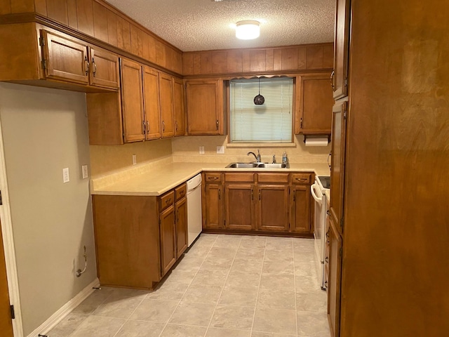 kitchen featuring a textured ceiling, sink, and white appliances