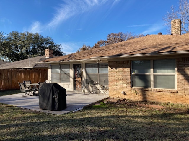 rear view of house featuring a lawn and a patio area