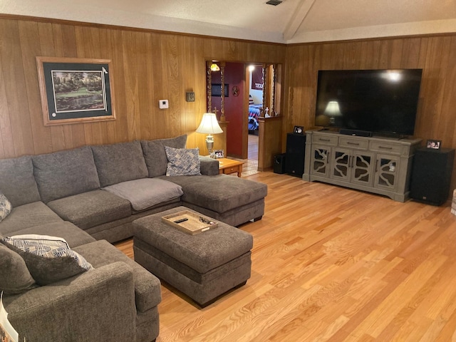 living room featuring hardwood / wood-style flooring, beamed ceiling, and wooden walls