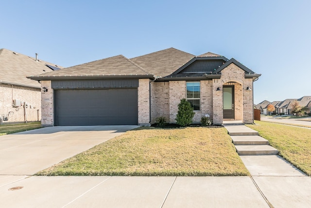 view of front of house featuring a garage and a front lawn