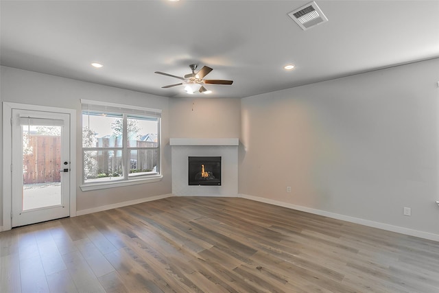 unfurnished living room featuring hardwood / wood-style flooring and ceiling fan