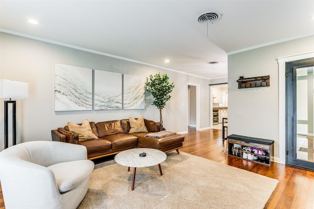 living room featuring hardwood / wood-style flooring and ornamental molding