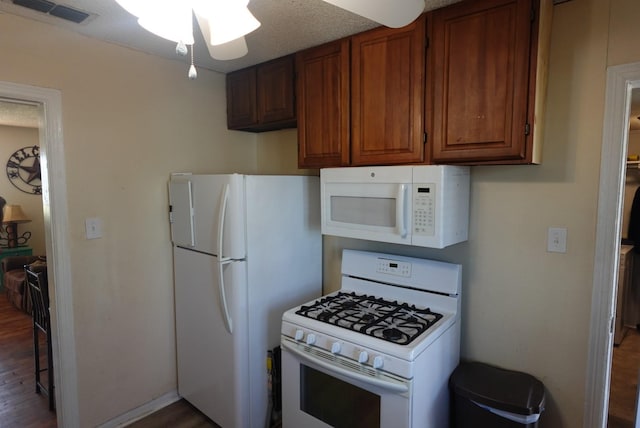 kitchen with dark hardwood / wood-style flooring and white appliances