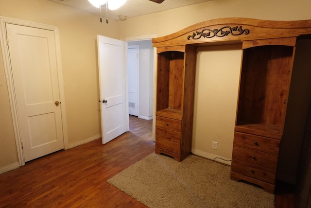 unfurnished bedroom featuring ceiling fan, dark hardwood / wood-style flooring, and a textured ceiling