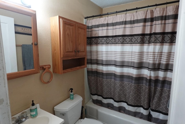 full bathroom with shower / bath combo, toilet, a textured ceiling, and vanity