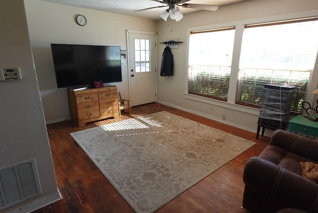 living room with ceiling fan, dark wood-type flooring, and a wealth of natural light