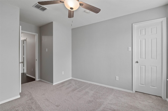 spare room with ceiling fan and light carpet