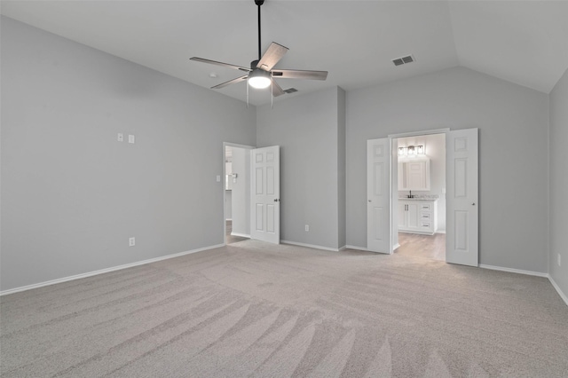 unfurnished bedroom featuring high vaulted ceiling, light colored carpet, ensuite bath, and ceiling fan