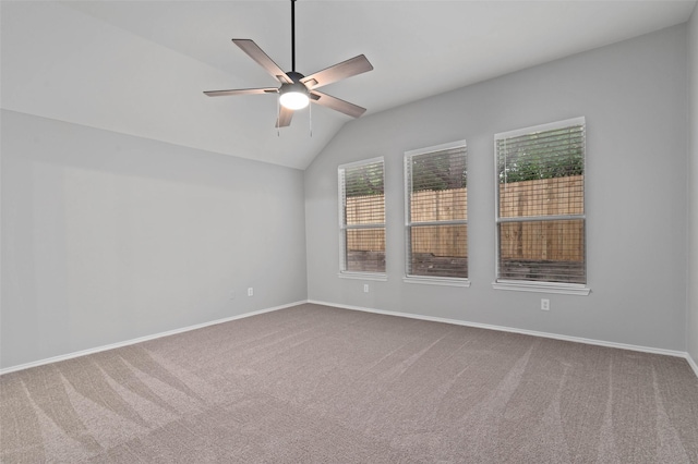 carpeted spare room featuring vaulted ceiling and ceiling fan