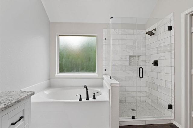 bathroom with vanity, vaulted ceiling, and shower with separate bathtub