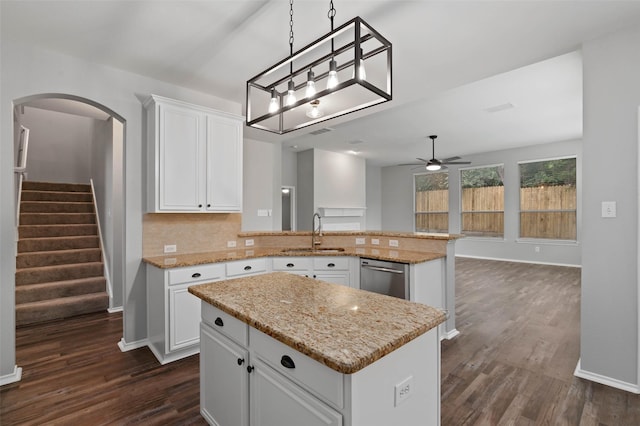 kitchen featuring kitchen peninsula, ceiling fan, sink, white cabinets, and a center island