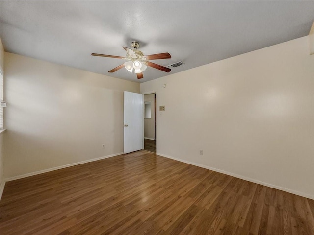 unfurnished room featuring dark wood-type flooring and ceiling fan