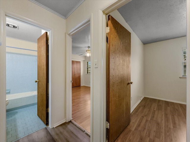 hall featuring ornamental molding and light hardwood / wood-style flooring