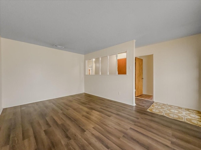 unfurnished room with dark hardwood / wood-style flooring