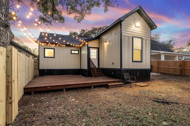 back house at dusk with a deck