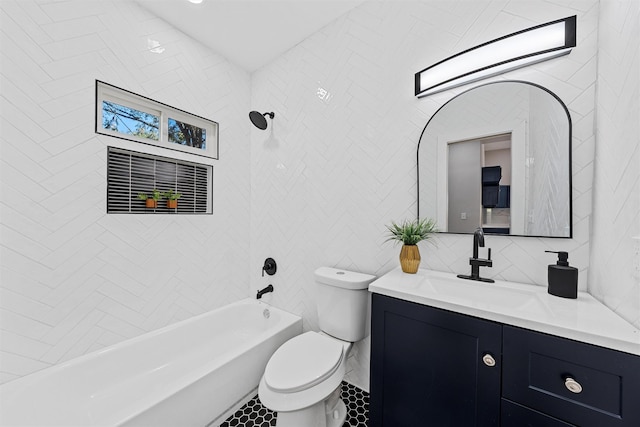 full bathroom with vanity, tile walls, tile patterned flooring, toilet, and tiled shower / bath