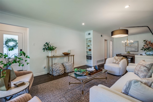 living room featuring built in features, an inviting chandelier, dark hardwood / wood-style floors, and ornamental molding