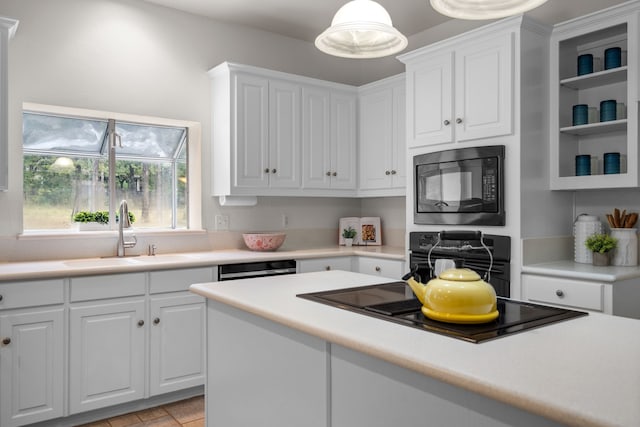 kitchen with sink, decorative light fixtures, white cabinetry, and black appliances