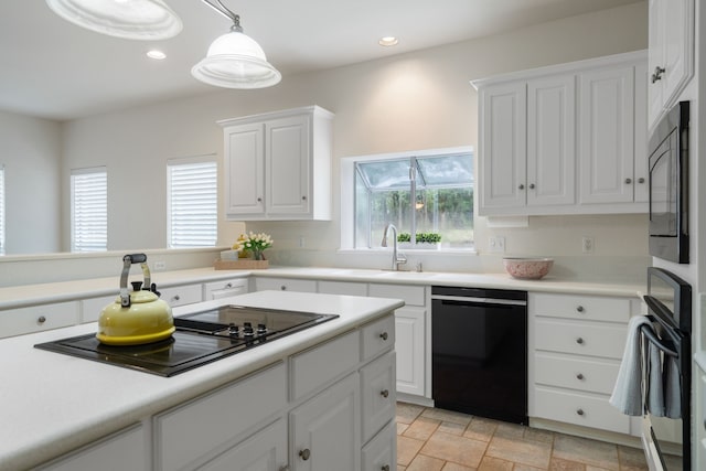 kitchen featuring black appliances, pendant lighting, white cabinetry, and sink